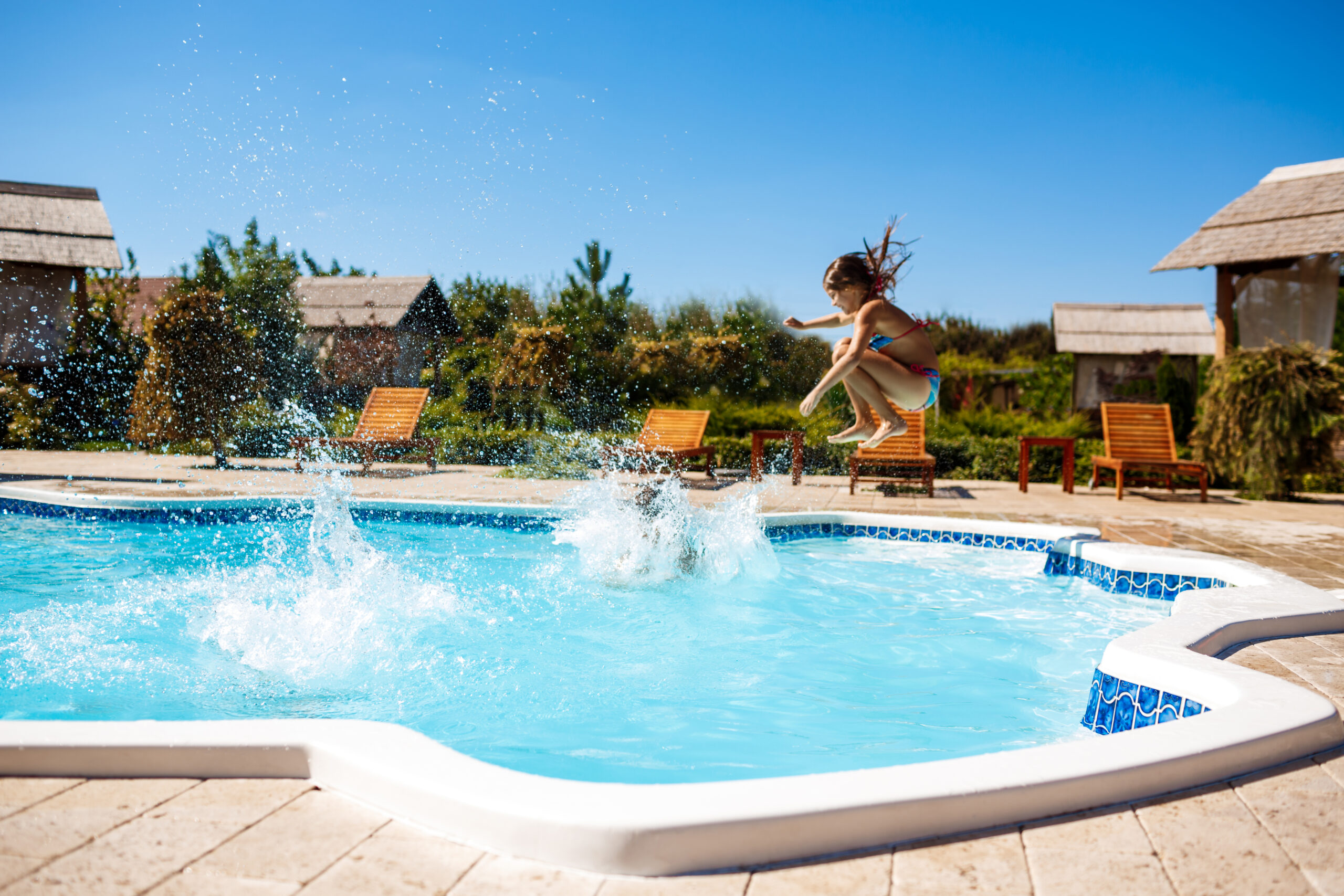 Cheerful children rejoicing, jumping, swimming in pool. Copy space